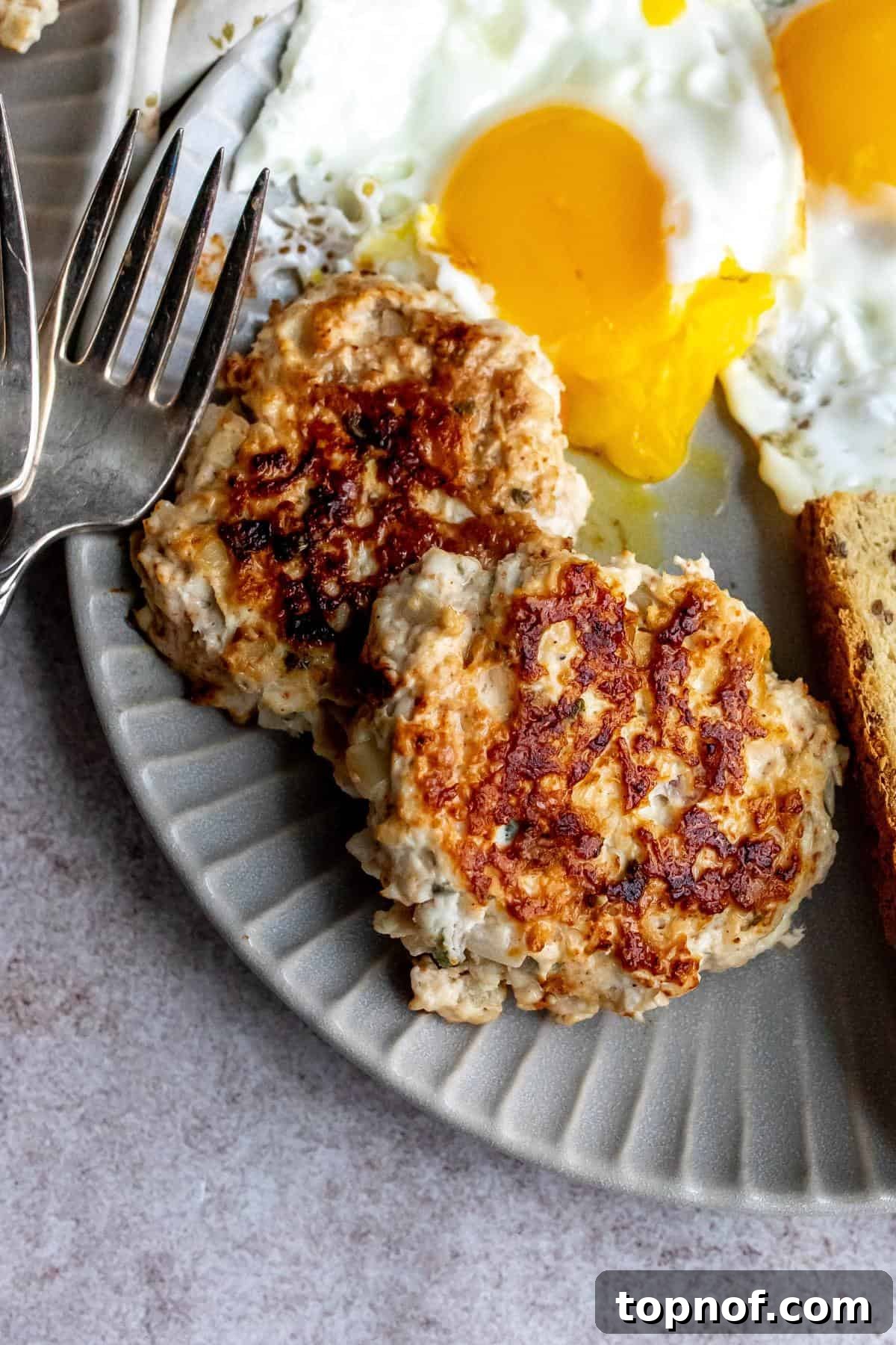A close-up view of a perfectly cooked chicken and apple sausage patty, showcasing its golden-brown exterior and juicy, flavorful interior.