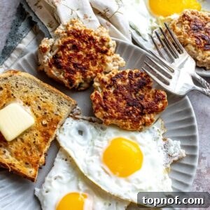 An image of chicken apple sausage with eggs and bread on a plate.
