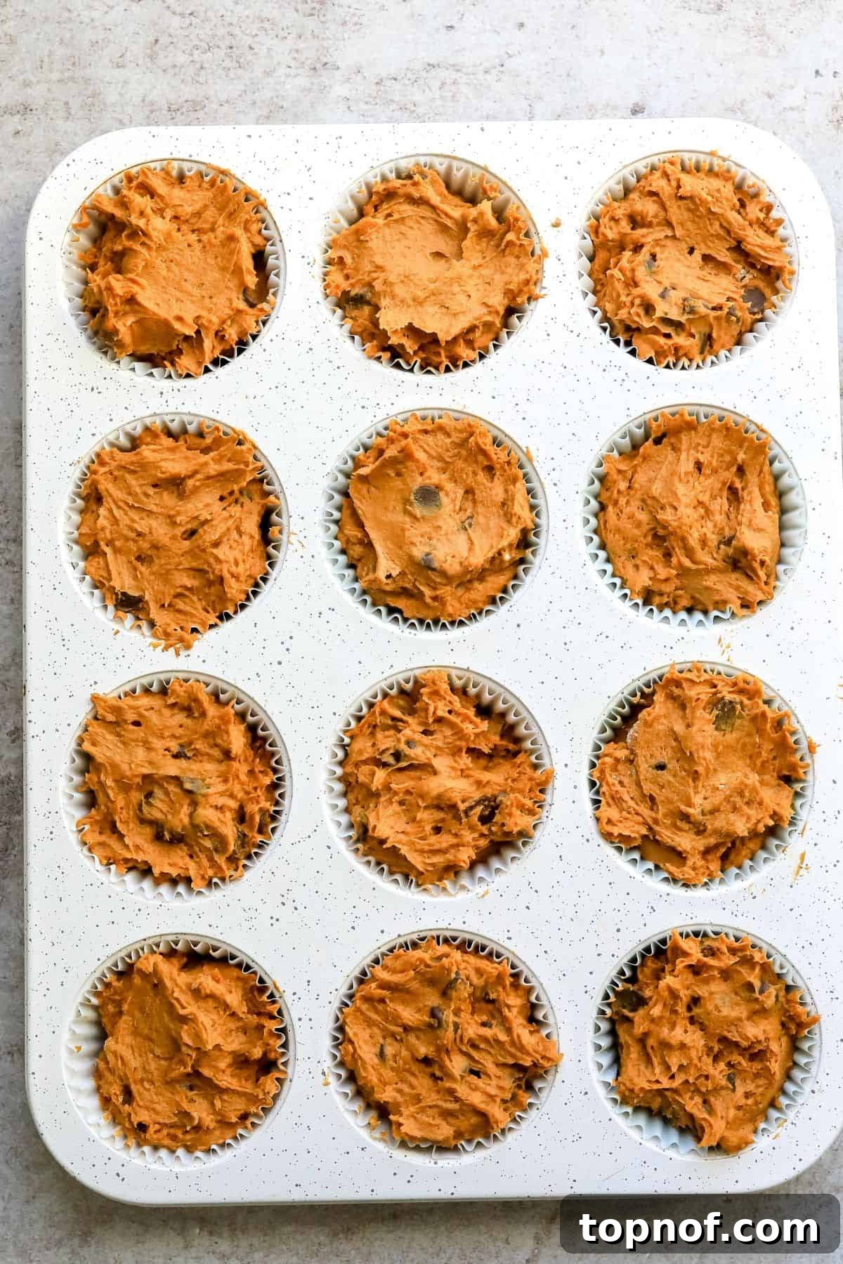 Effortless 3 Ingredient Pumpkin Muffins 4 Muffin tin with raw pumpkin bread mix prepared with cake mix, ready for baking.