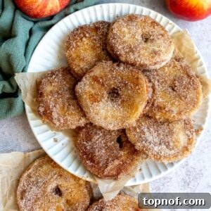 An overhead image of a stack of apple donuts on a plate.