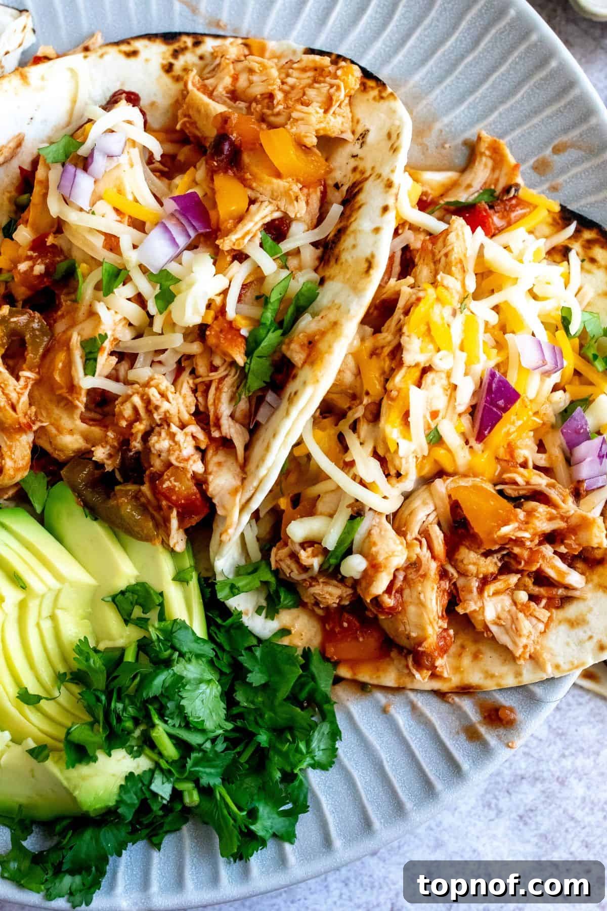 Weeknight Slow Cooker Chicken Tacos 5 Plate with lines on it and three slow cooker chicken tacos up close photo.