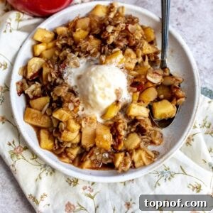 White plate with Slow Cooker Apple Crisp on it and melted ice cream.