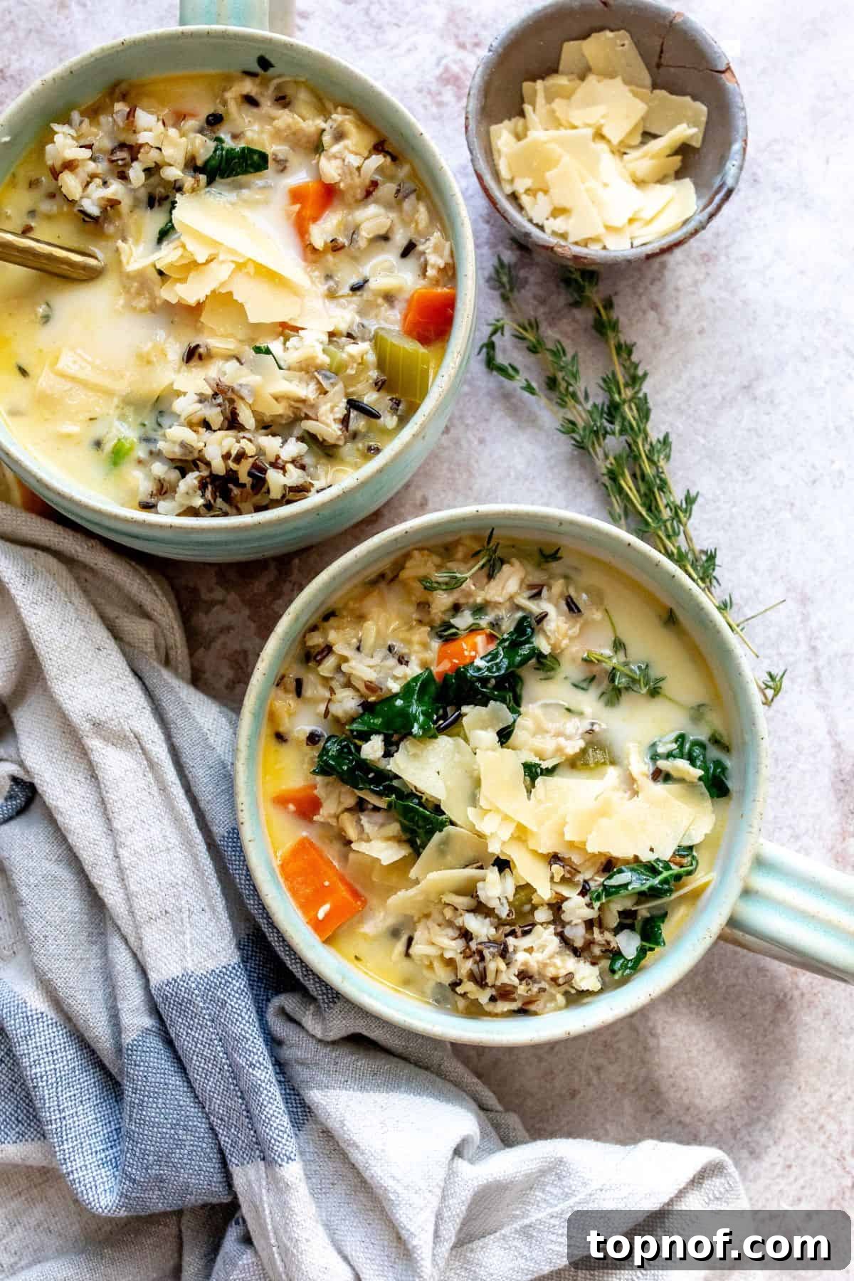 Velvety Chicken Wild Rice Soup 2 Cozy bowl of Creamy Chicken Wild Rice Soup, garnished with fresh herbs and a spoon.