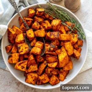 Crispy Roasted Sweet Potatoes in a bowl with a silver antique spoon.