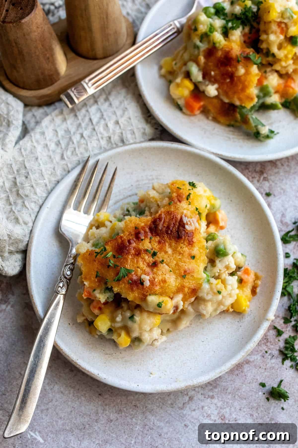 Nourishing Chicken Cobbler Bake 2 A perfectly portioned slice of golden-brown chicken cobbler, showcasing its creamy filling and fluffy biscuit topping, served on a white plate, ready to be enjoyed.