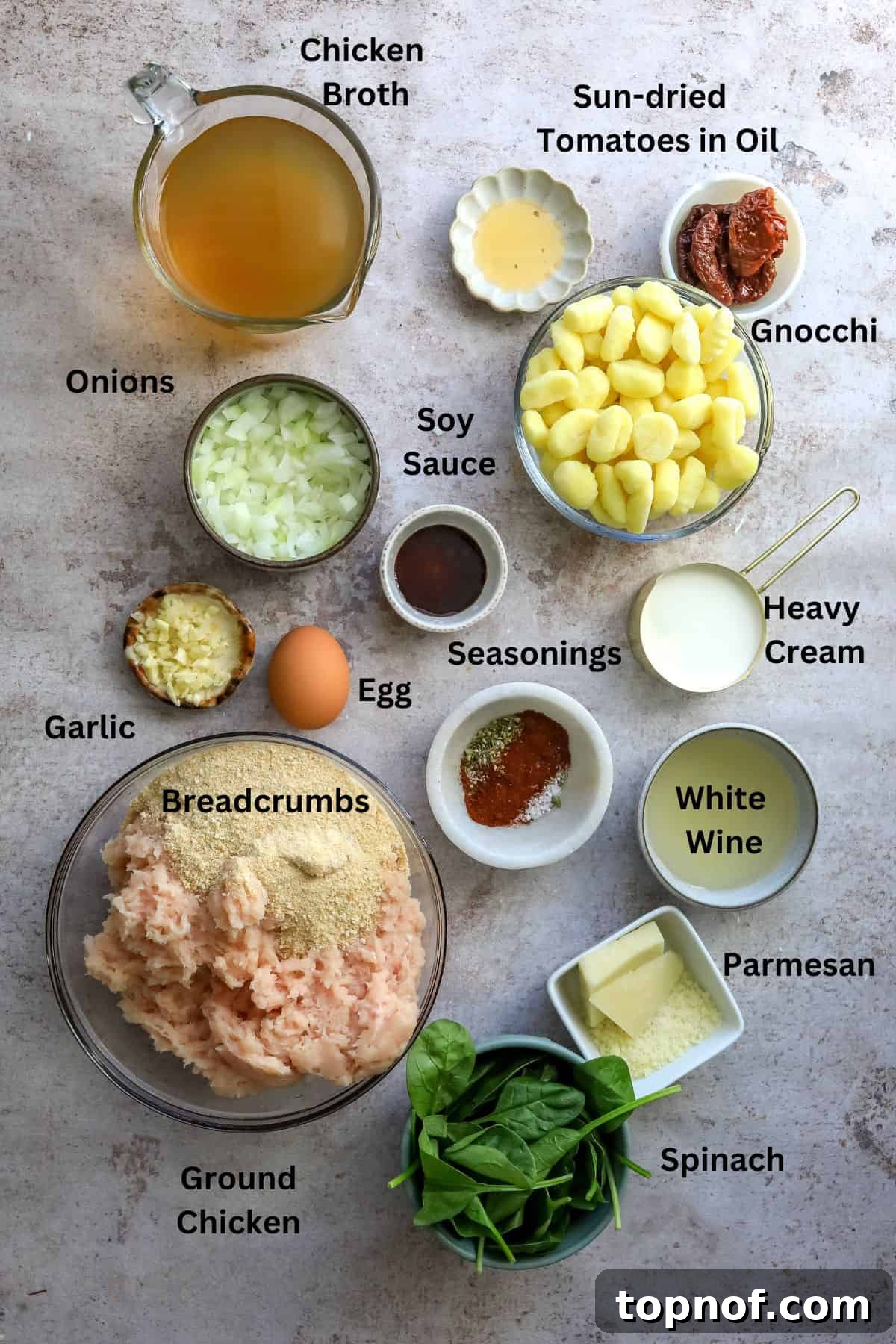 Creamy Slow Cooker Tuscan Chicken Meatball Gnocchi 3 Various fresh ingredients neatly arranged on a kitchen counter in small bowls and measuring cups, ready for making Slow Cooker Tuscan Chicken Meatballs with Gnocchi.