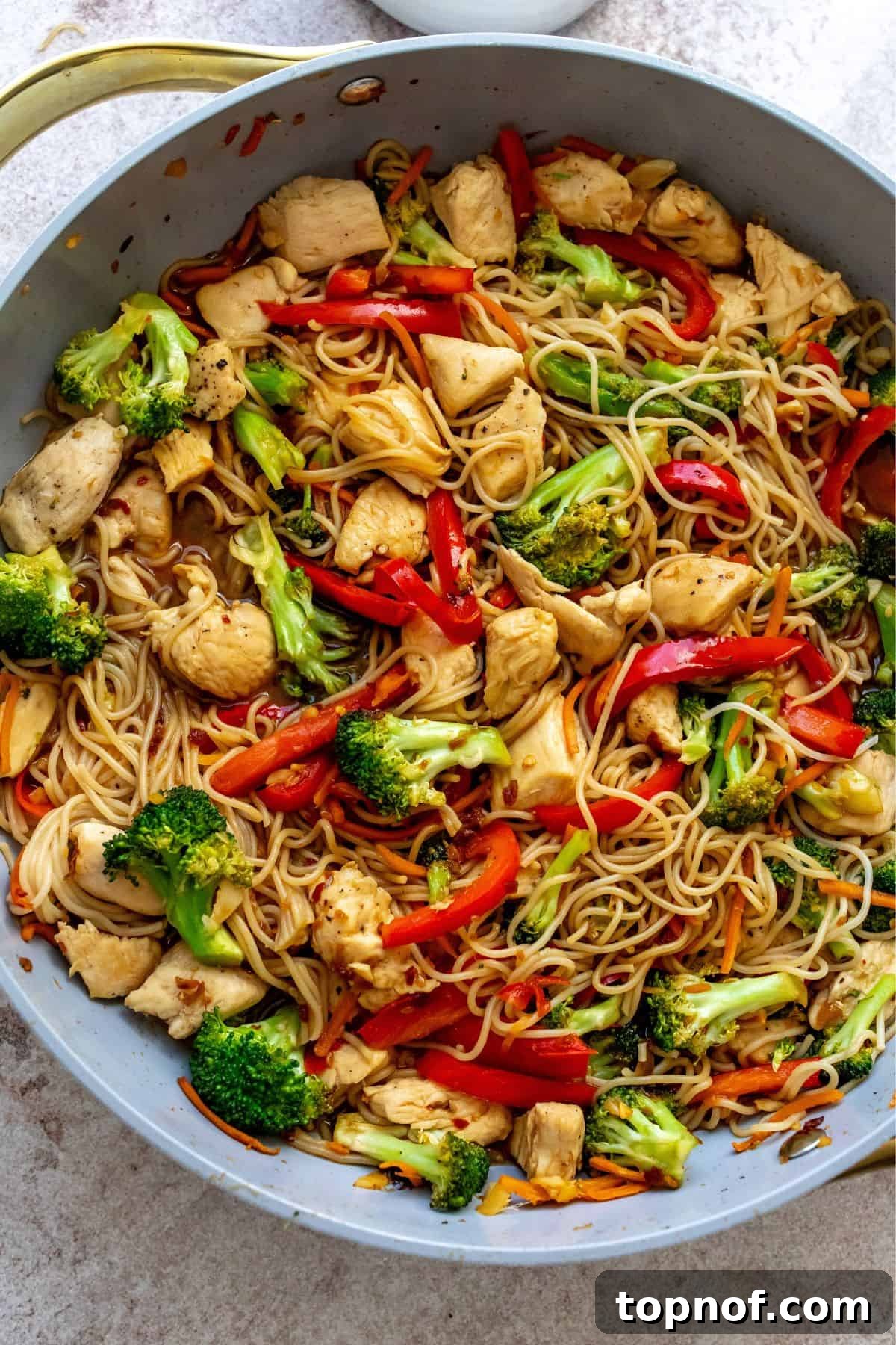 Savory Teriyaki Chicken Ramen Bowl 5 Close-up view of Teriyaki Chicken Ramen cooked in a skillet, showcasing tender chicken, brightly colored vegetables like broccoli and bell peppers, and ramen noodles coated in a rich teriyaki sauce, ready to be served.