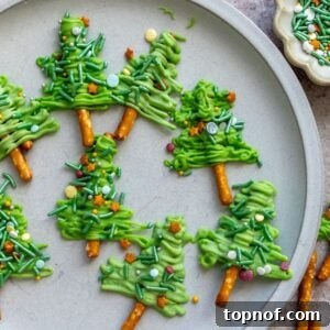 White plate with Pretzel Christmas Trees on it and sprinkles on the side.