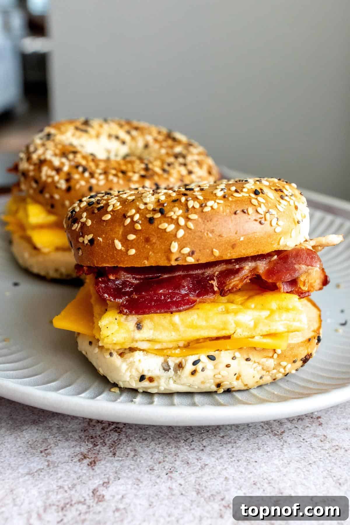Morning Rush Breakfast Sandwiches 2 Delicious freezer breakfast bagel sandwiches with crispy bacon and melted cheese on a plate, ready to be enjoyed.
