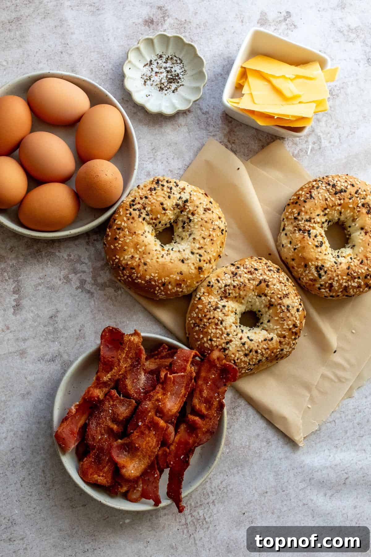 Morning Rush Breakfast Sandwiches 3 Fresh ingredients laid out on a kitchen counter, including eggs, bacon, cheese, and bagels, ready for assembly.