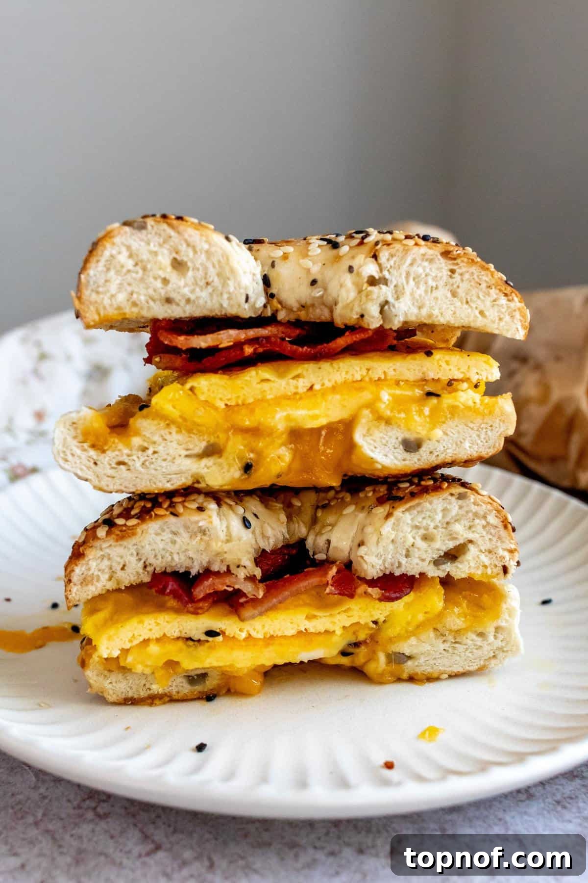 Morning Rush Breakfast Sandwiches 6 A perfectly reheated freezer breakfast sandwich with bacon and melted cheese, served on a white plate, showcasing its delicious appeal.