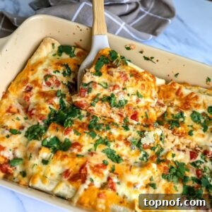 Cheesy White Enchiladas in a baking dish with bubbly cheese and cilantro.