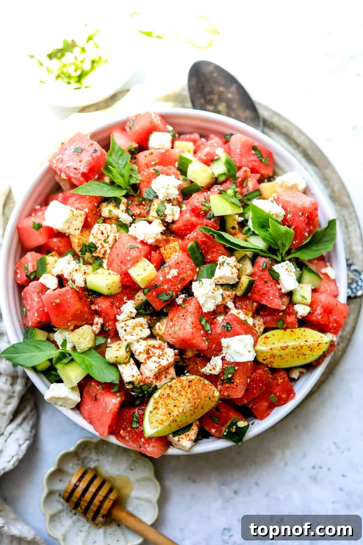 Watermelon Basil Bliss 2 A crisp, close-up shot of Watermelon Feta Salad, beautifully arranged in a white ceramic bowl, garnished with fresh basil leaves.