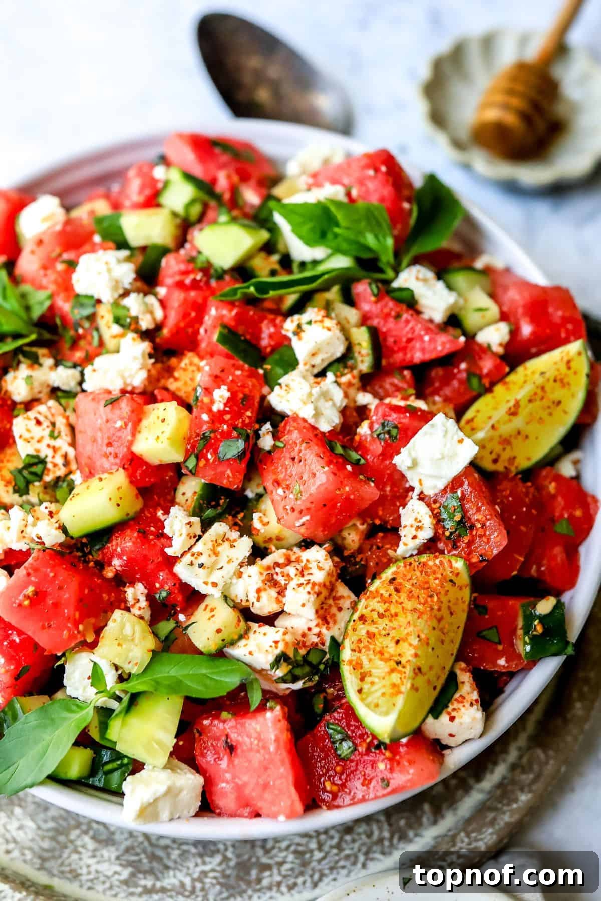 Watermelon Basil Bliss 5 An inviting close-up photo of the finished Watermelon Feta Salad in a white ceramic bowl, garnished with fresh lime slices and basil, highlighting its vibrant colors.