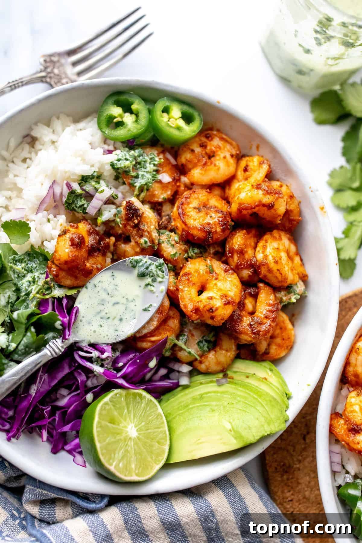 Bold Blackened Shrimp Bowl 6 White ceramic bowl with Blackened Shrimp and toppings, drizzled with cilantro dressing.