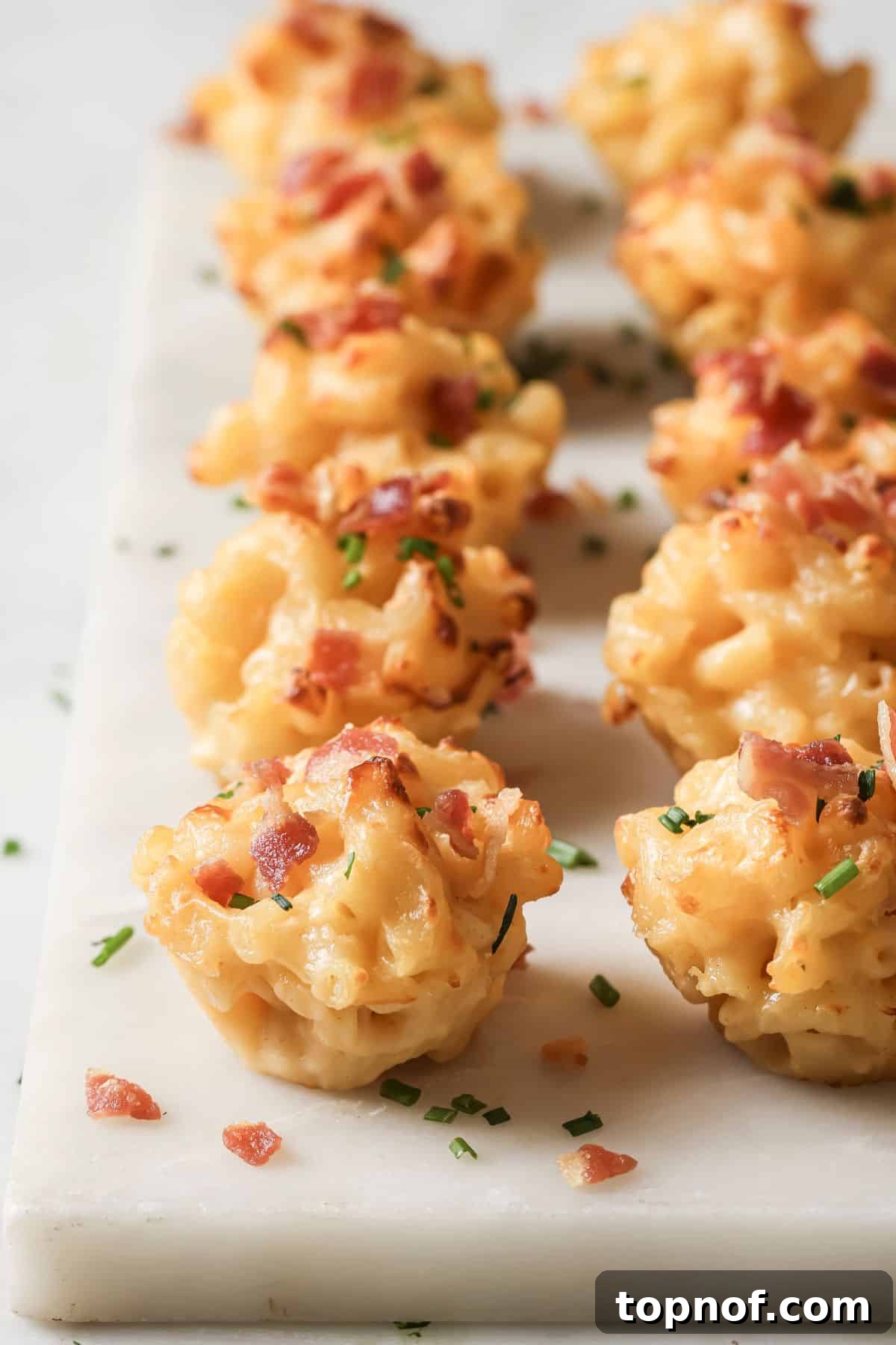 Mac N Cheese Minis 6 An image of a column of mini macaroni bites arranged beautifully on a serving tray.
