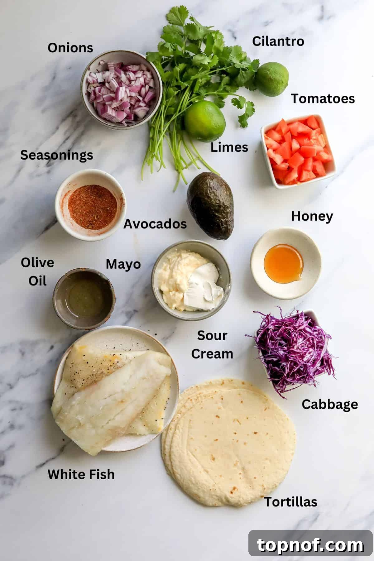 Cajun-Spiced Fish Tacos 3 An overhead shot of all the fresh, colorful ingredients laid out on a white countertop, ready for preparing the Blackened Fish Tacos and Zesty Crema.