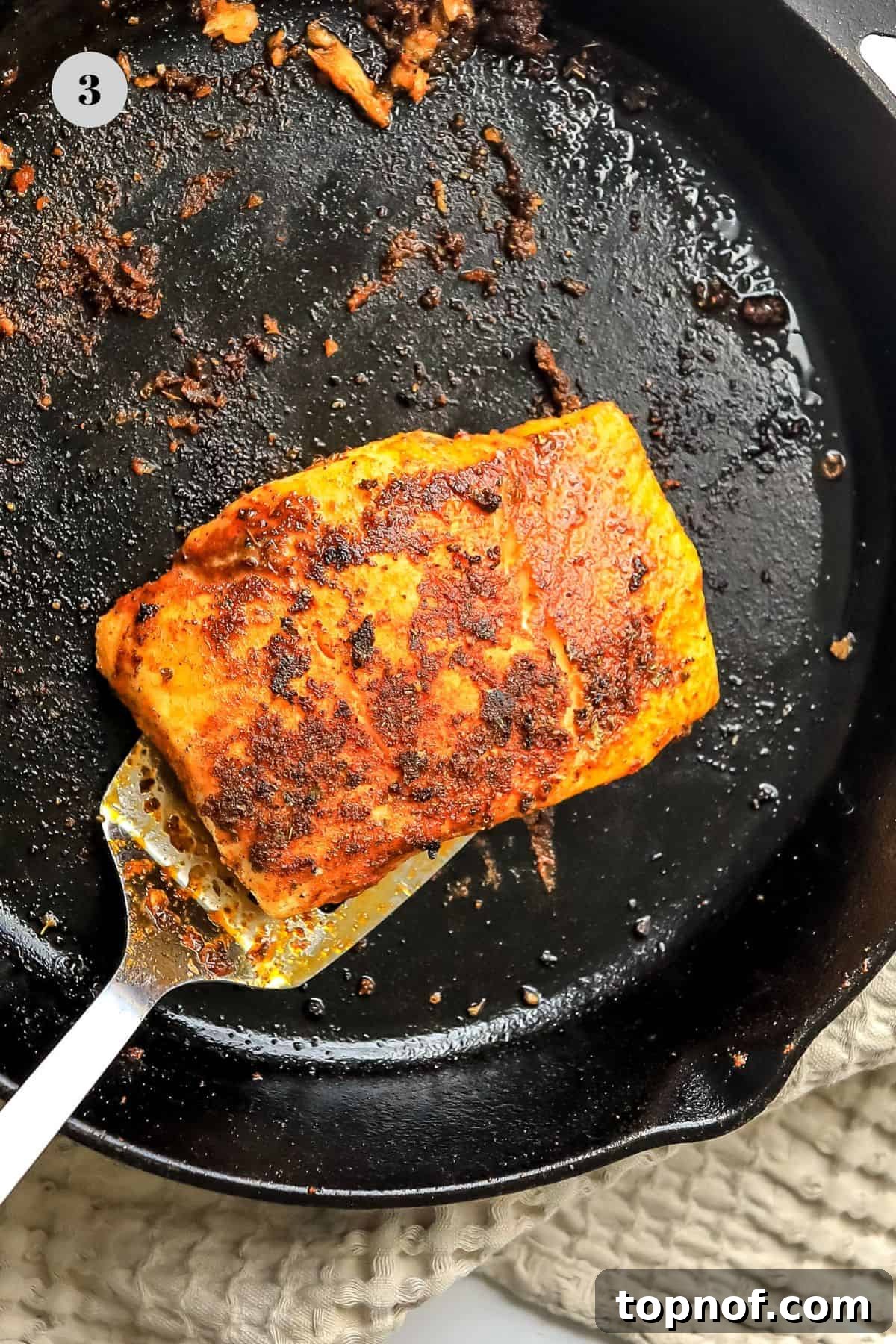 Cajun-Spiced Fish Tacos 5 A fish fillet cooking in a hot skillet, with a spatula poised to flip it, demonstrating the blackening process.