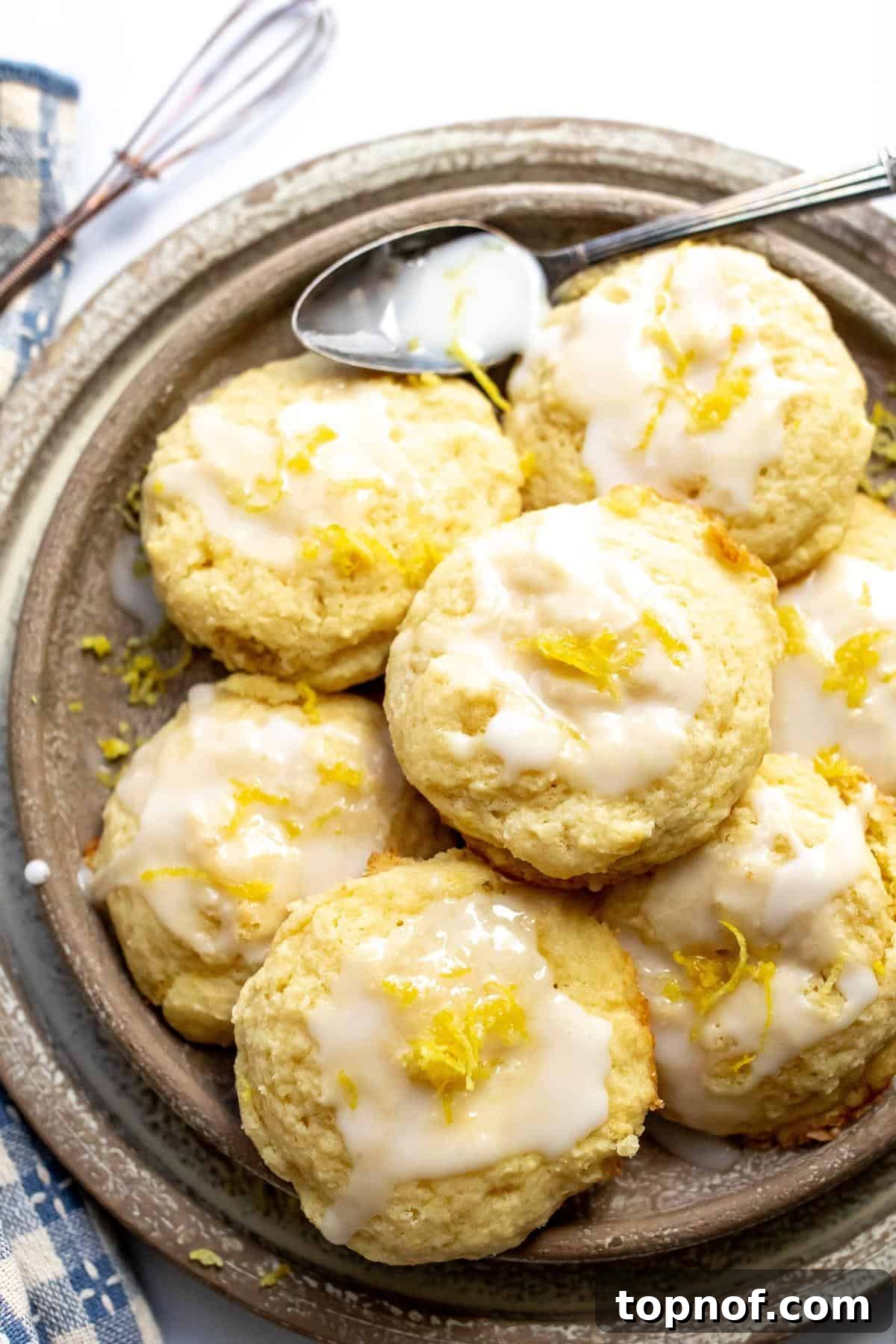 Zesty Ricotta Cloud Cookies 2 Beautifully glazed Lemon Ricotta Cookies arranged on a rustic beige plate, ready to be enjoyed.