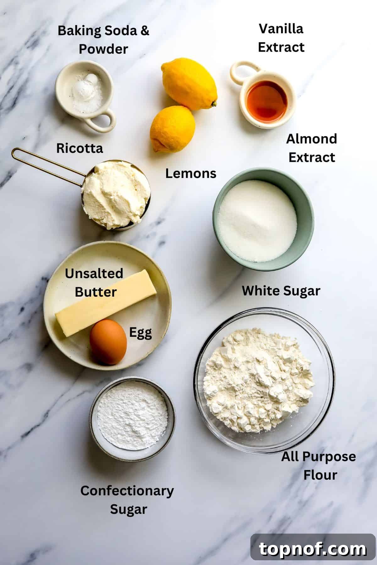 Zesty Ricotta Cloud Cookies 3 Variety of baking ingredients, including fresh lemons, butter, flour, and sugar, laid out on a kitchen counter, ready for mixing.