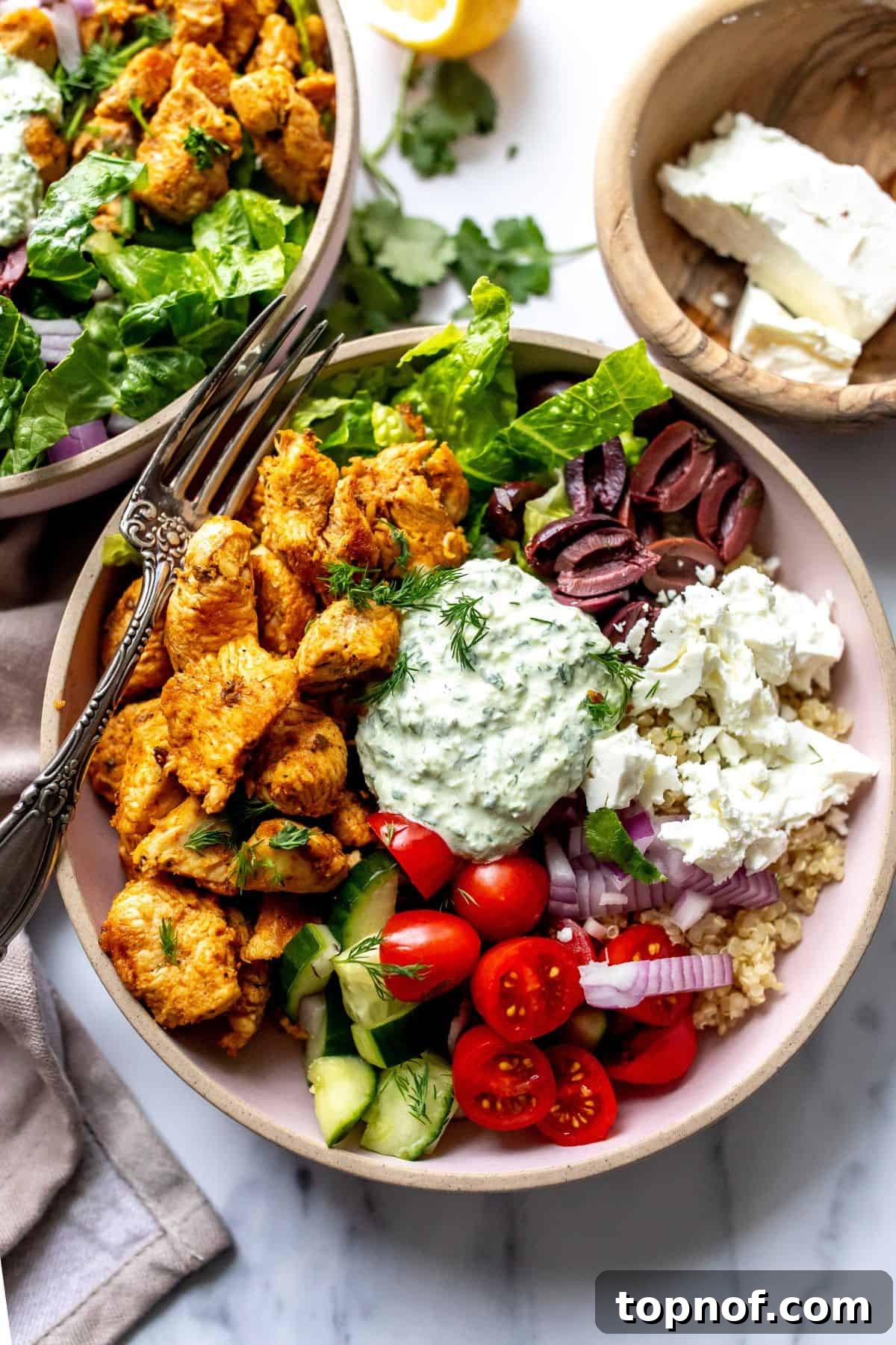 Pink ceramic bowls filled with colorful Chicken Gyro and abundant fresh toppings, ready to be enjoyed.