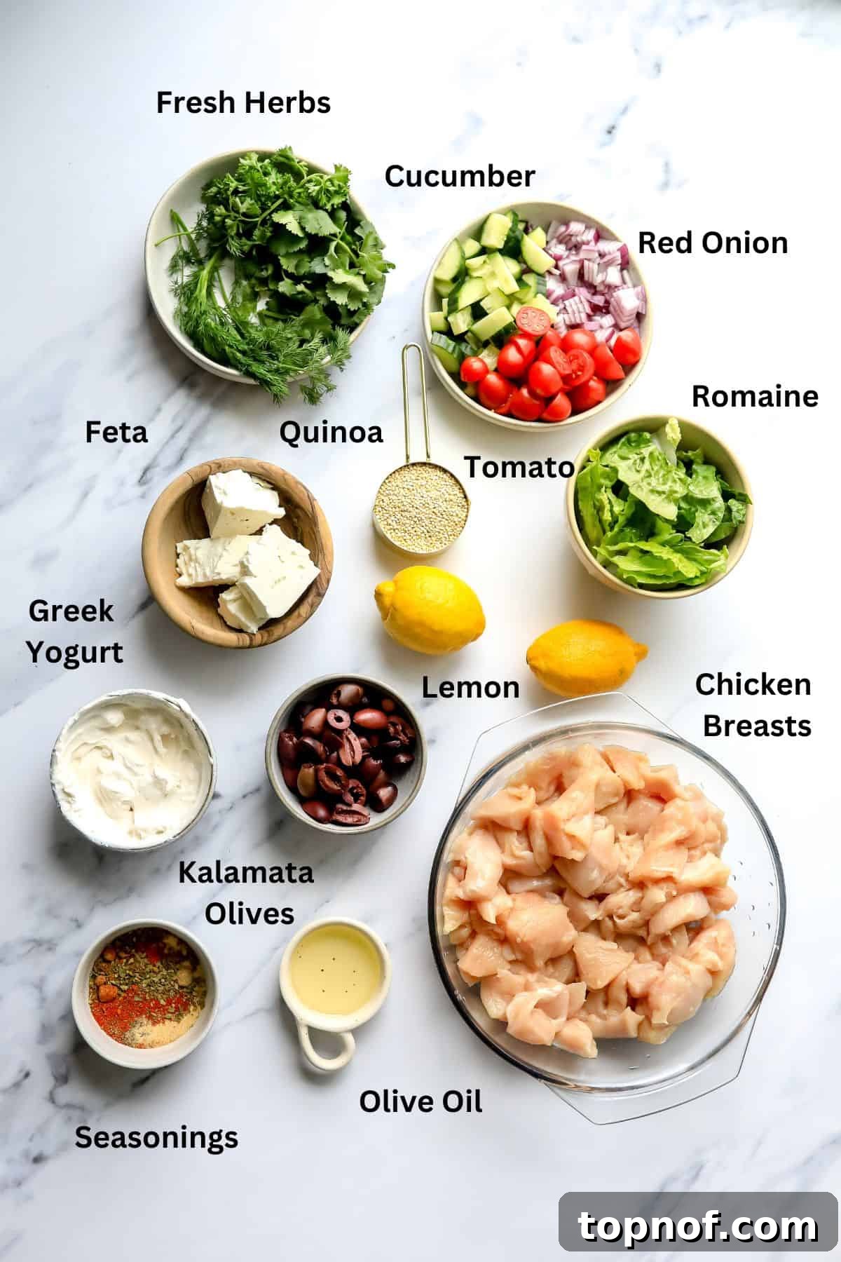 A vibrant overhead shot showcasing fresh ingredients for Chicken Gyro Bowls neatly arranged in bowls on a white marble countertop.