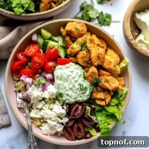 Pink ceramic bowls with Chicken Gyro in them and lots of colorful toppings.