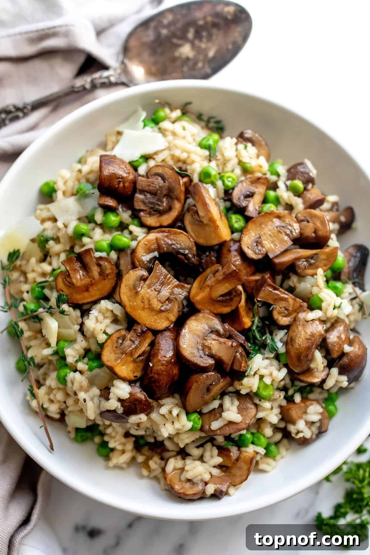 Creamy Mushroom and Pea Risotto 2 A vibrant flat lay of fresh ingredients for mushroom pea risotto, including Arborio rice, mushrooms, peas, garlic, onion, and herbs.