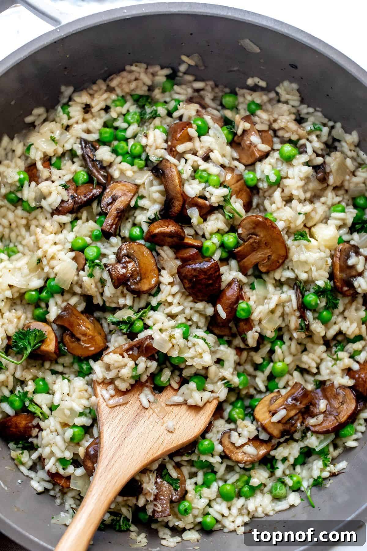 Creamy Mushroom and Pea Risotto 5 An inviting overhead shot of a skillet filled with rich, creamy mushroom pea risotto, garnished with fresh parsley, ready to serve.