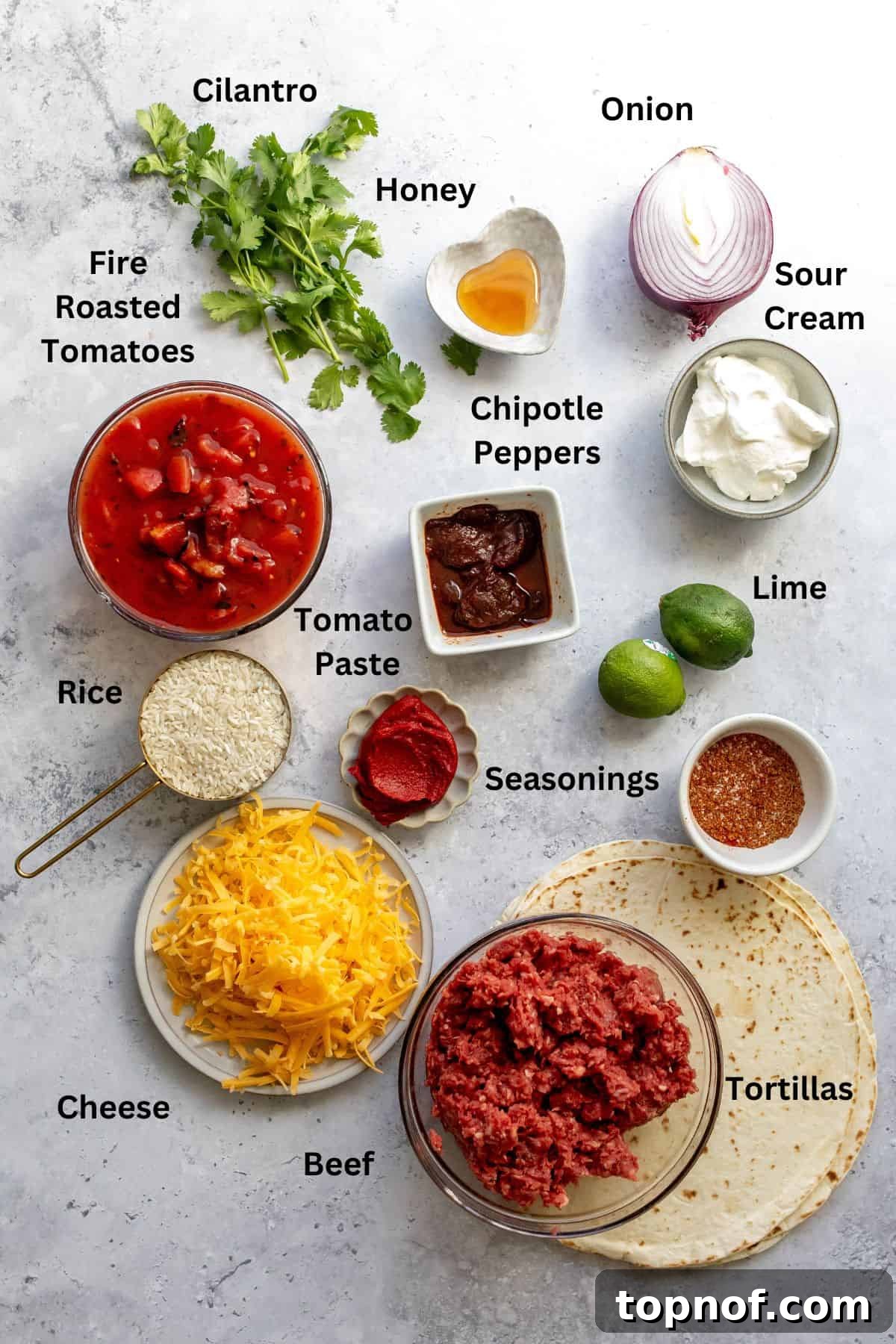 The Iconic Grilled Cheese Burrito Reimagined 3 An overhead view of all fresh ingredients laid out on a table, including ground beef, spices, tomatoes, rice, and tortillas, ready for making grilled cheese burritos.