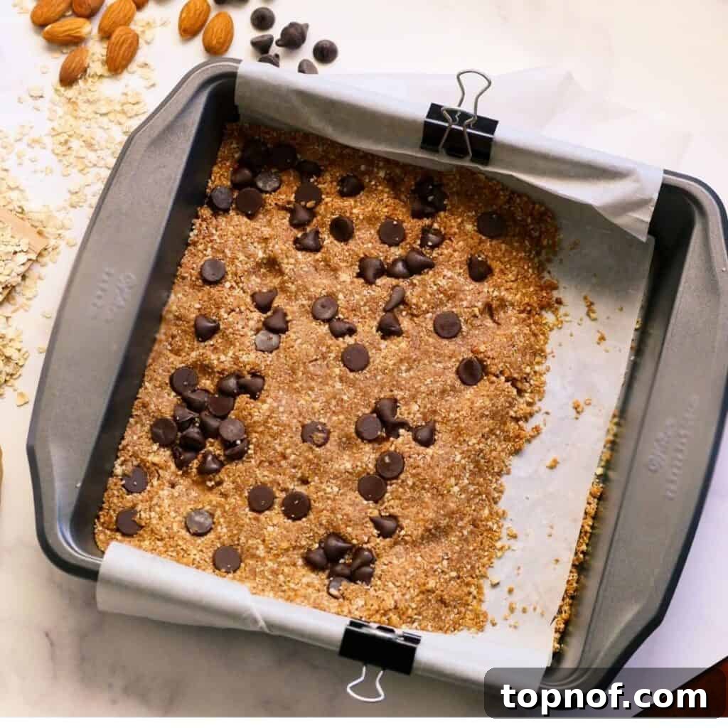 Plant-Powered Granola Bars 5 Finished no-bake granola bars, generously studded with dark chocolate chips, ready for chilling.