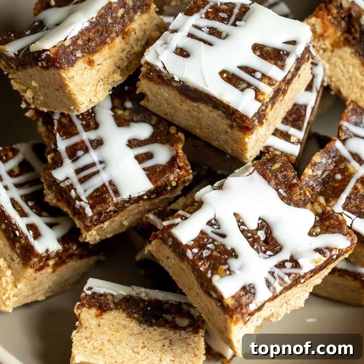 Golden Chewy No-Bake Blondie Squares 4 Chewy no-bake blondies drizzled with white chocolate icing, ready to be served.