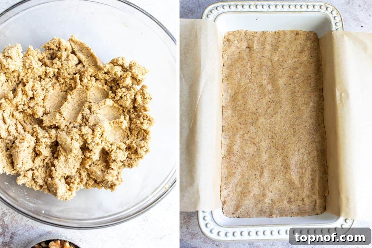 Golden Chewy No-Bake Blondie Squares 5 Clear bowl with blondie base layer batter, and batter pressed into a parchment-lined bread tin.