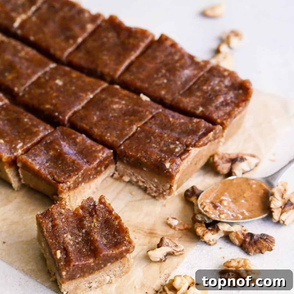 Golden Chewy No-Bake Blondie Squares 8 No-bake blondies with walnuts on parchment paper, ready to be stored or served.