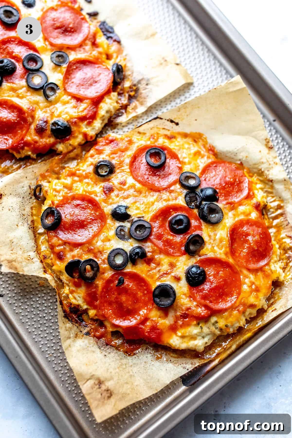 Keto Chicken Pizza 5 Chicken pizza crust on parchment paper, perfectly shaped and ready for baking.