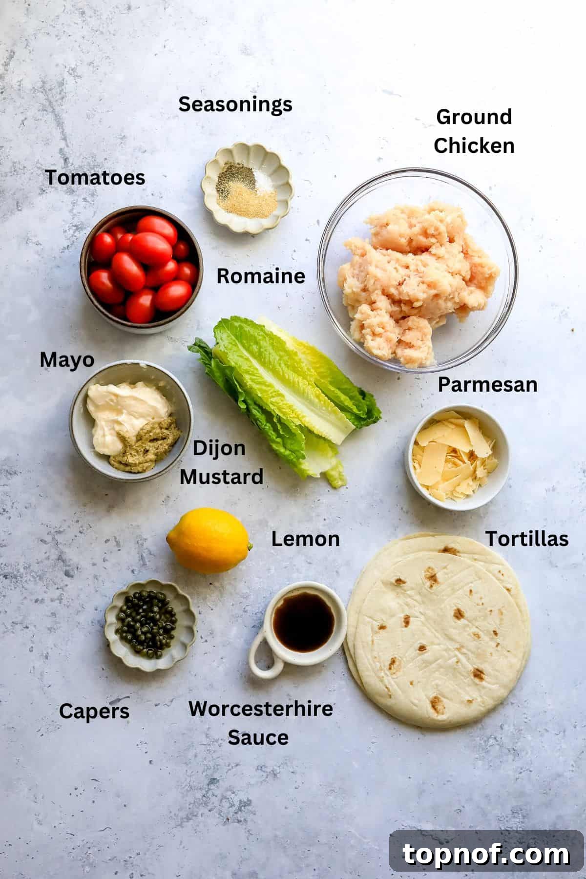 Caesar Chicken Smash Tacos 3 Fresh ingredients meticulously laid out on a clean kitchen counter in various bowls, ready for the preparation of Chicken Caesar Smashed Tacos.