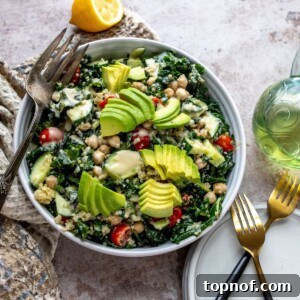 A vibrant Chickpea Kale Salad, richly dressed and topped with various fresh vegetables, served in a white bowl, ready for enjoyment.