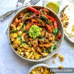 Grey bowl with Chicken fajita in it over rice with guacamole.