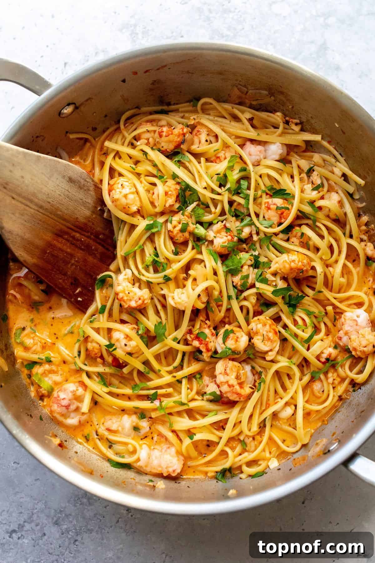 A close-up shot of creamy lobster pasta, showcasing tender lobster pieces, intertwined with perfectly coated linguine in a rich, savory sauce, ready to be served.