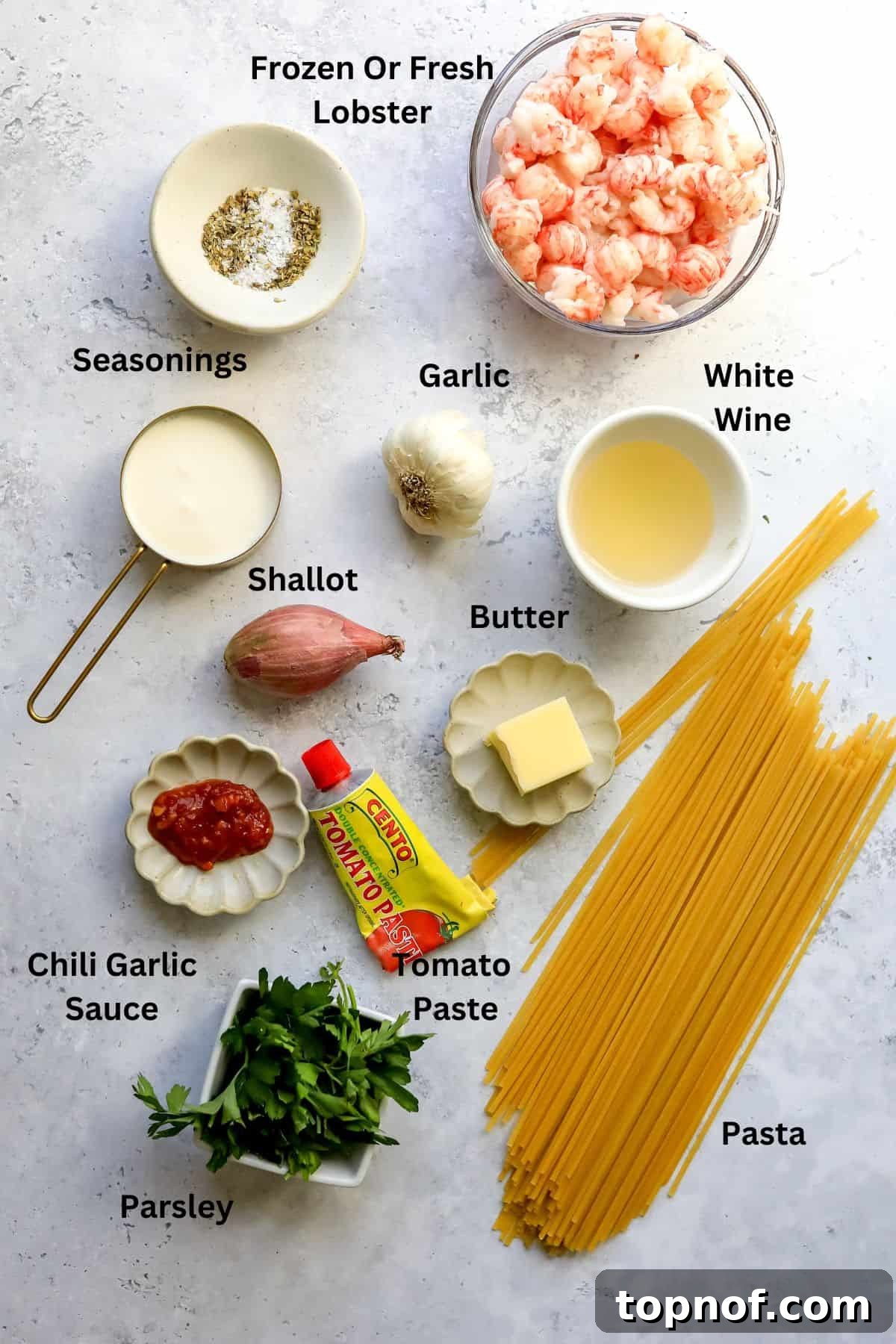 A vibrant selection of fresh ingredients laid out, including finely diced shallots, garlic cloves, rich tomato paste, and various seasonings, ready for the lobster pasta preparation.