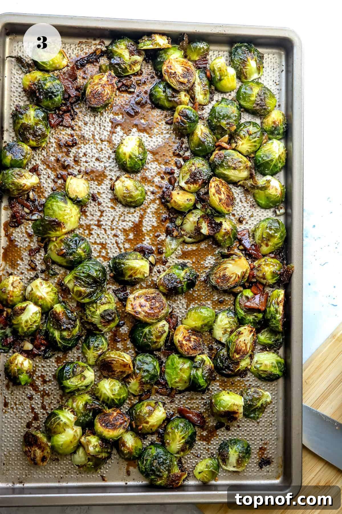 Baking sheet with perfectly arranged Brussels sprouts, flat side down, ready for roasting.