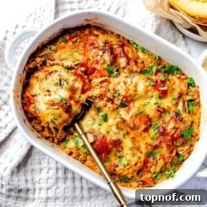 Spaghetti Squash Lasagna in a white casserole dish, featuring golden cheese and rich sauce.