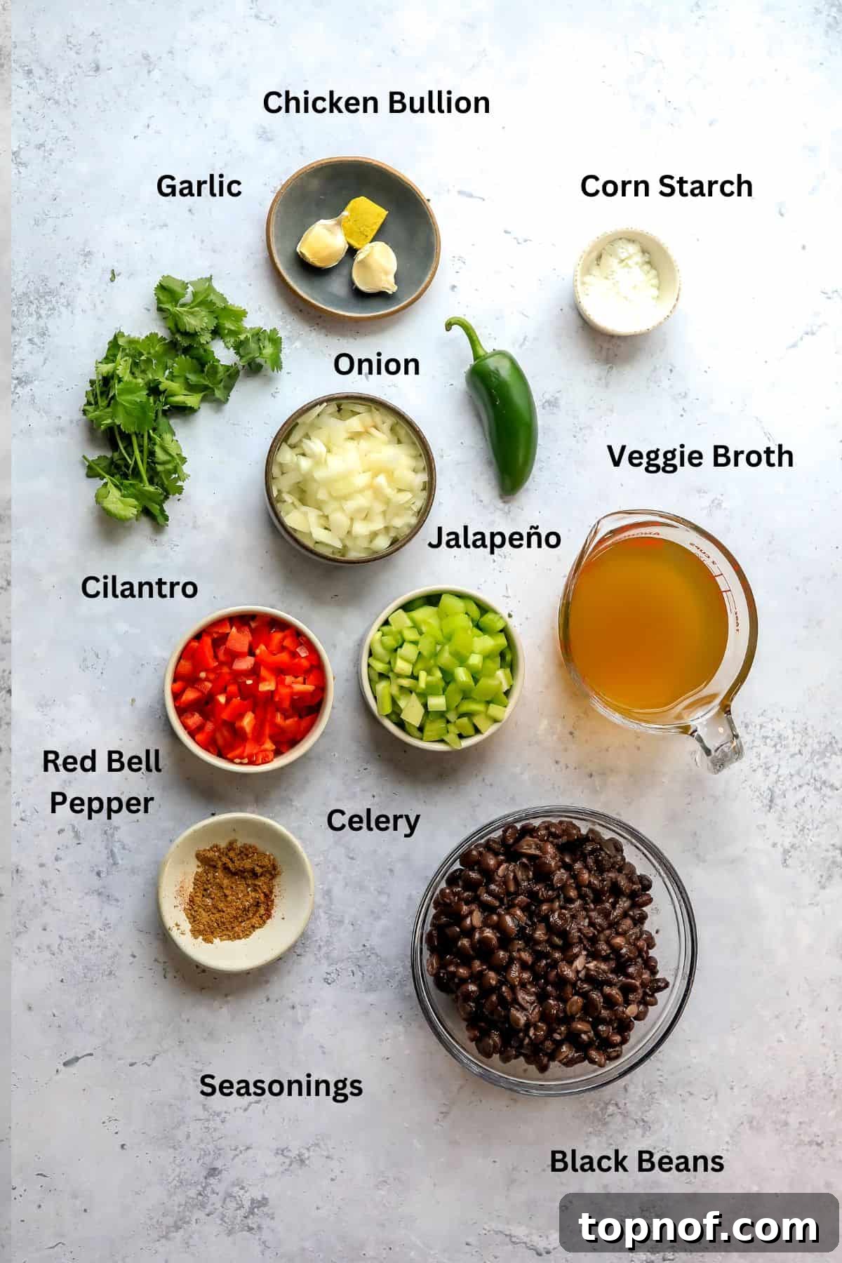 Rich Black Bean Comfort 3 A selection of fresh ingredients including black beans, bell peppers, onion, celery, and spices laid out on a countertop, ready for making homemade black bean soup.