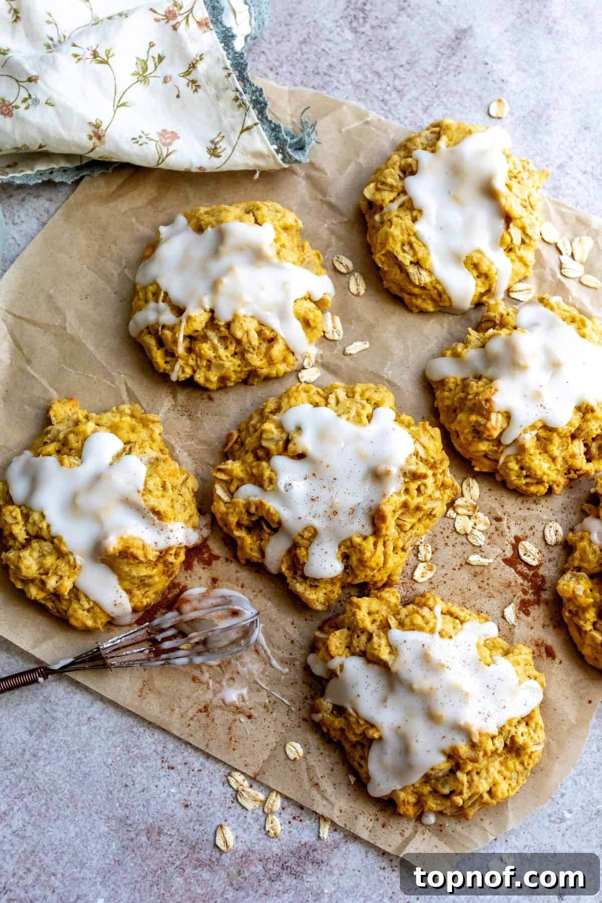 Harvest Pumpkin Spice Delights 2 Soft and chewy Pumpkin Pie Spice Cookies on parchment paper, sprinkled with oats, ready to be enjoyed.