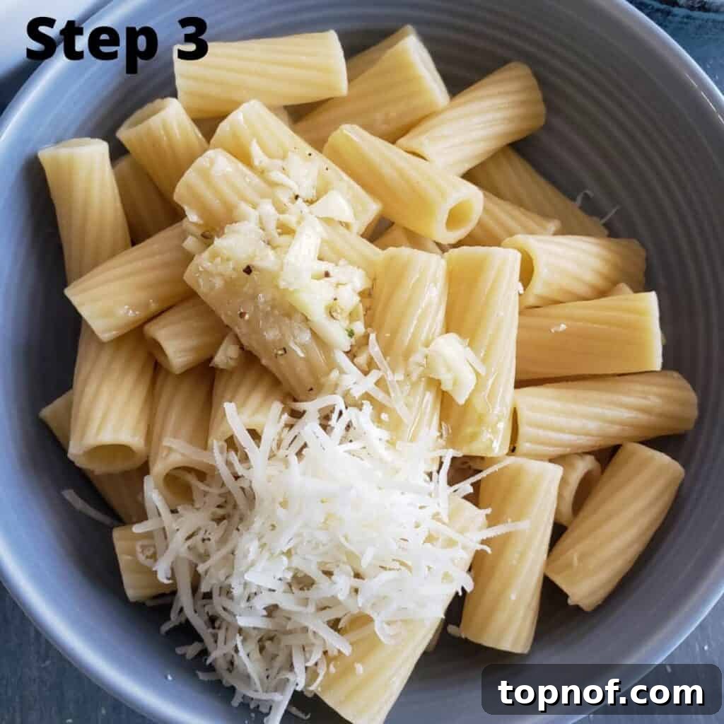 Roman Cheese and Pepper Pasta 5 Finished pasta with pecorino over it about to be mixed together in a gray bowl.