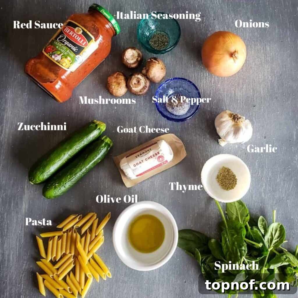 A vibrant selection of fresh ingredients laid out, including zucchini, mushrooms, spinach, pasta, sauce, and cheese, ready for the vegetarian pasta bake.