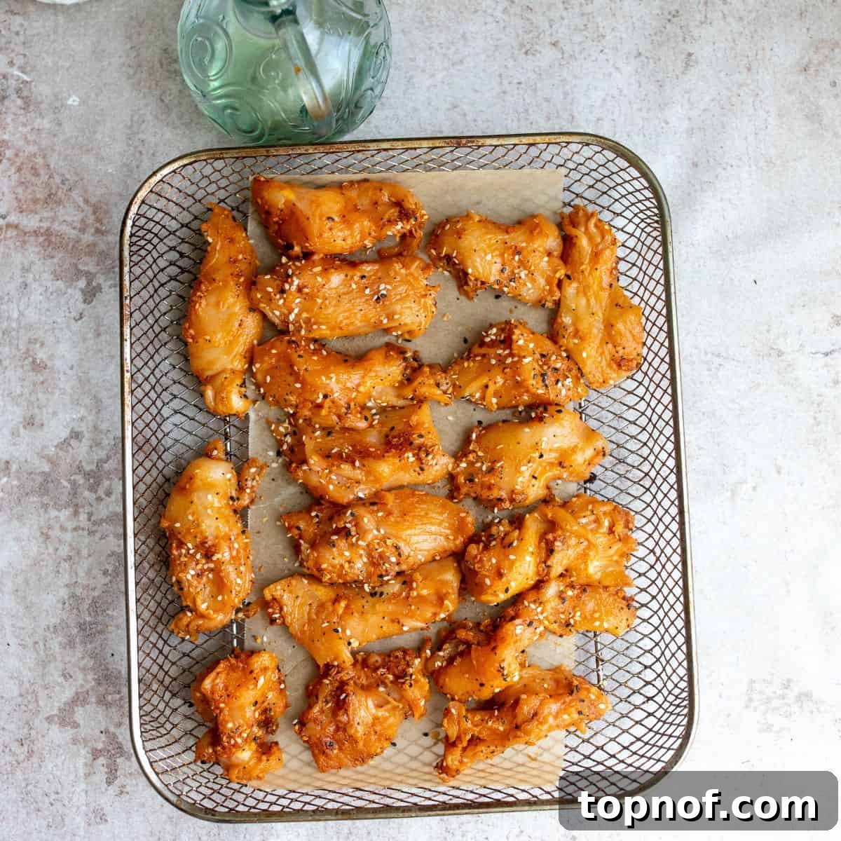 Pure Chicken Tenders 5 Naked Chicken Tenders arranged in a single layer on an air fryer tray, ready for cooking.