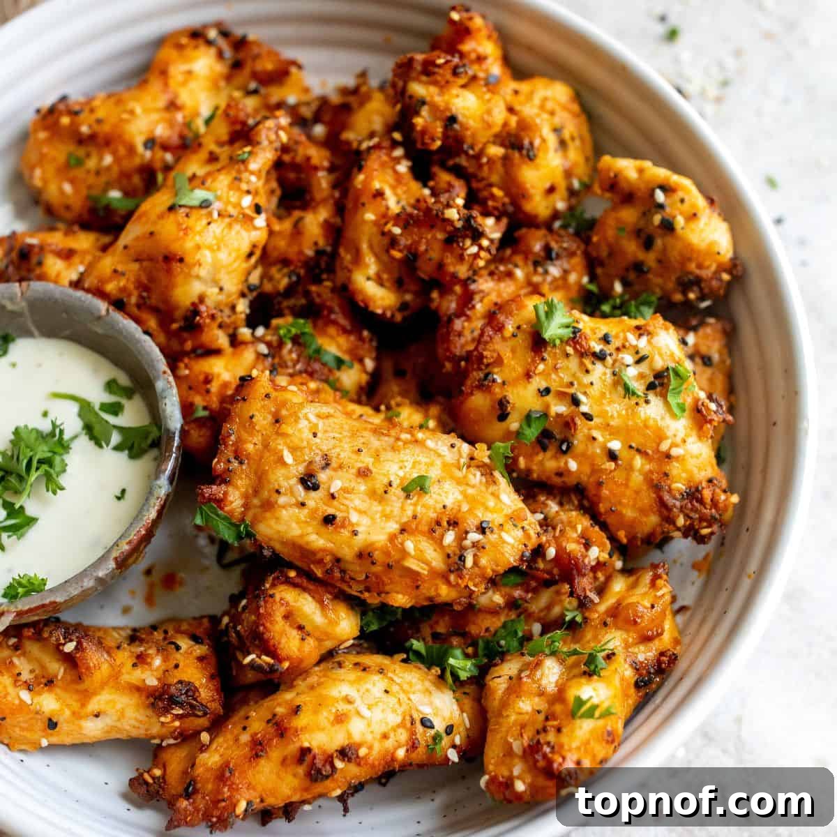 Pure Chicken Tenders 6 Close-up of Naked Chicken Tenders with visible seasoning and a small bowl of ranch dip.
