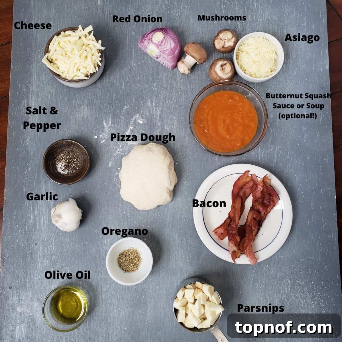 Golden Harvest Pizza 3 Ingredients for Harvest Pizza laid out on a rustic gray board, featuring fresh vegetables, cheeses, and sauce.