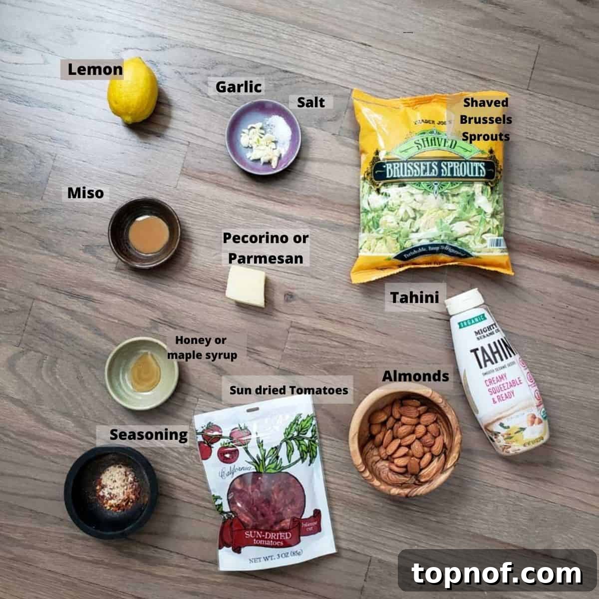 Brussels Ribbon Salad 3 Ingredients laid out on a kitchen counter, including fresh Brussels sprouts, sun-dried tomatoes, almonds, and tahini, ready to make the salad.